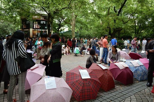 5年前に人民公園に来たときに撮影した写真。当時はチラシを地面に直に置かず、傘を開いて貼り付けていた。（2019年、筆者撮影）