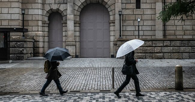 東京・日本銀行の前を通り過ぎる人々