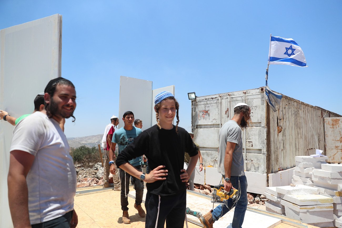 ユダヤ人入植地「エビアタル」で、プレハブ小屋の建設に取り組むユダヤ人入植者