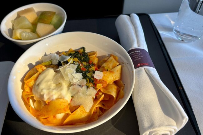 到着前の軽食はパッパルデッレパスタのトマトハーブソース仕立てとフルーツ