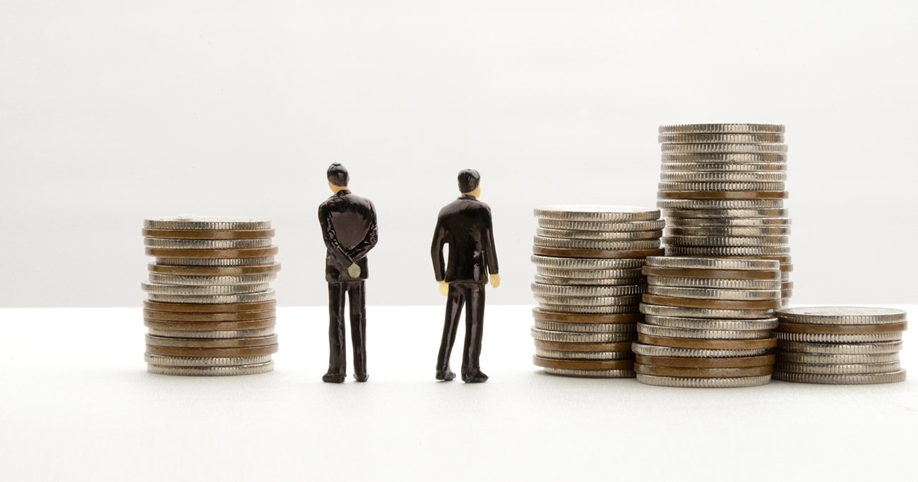 積み重ねた硬貨の前に立つ人物のイメージ