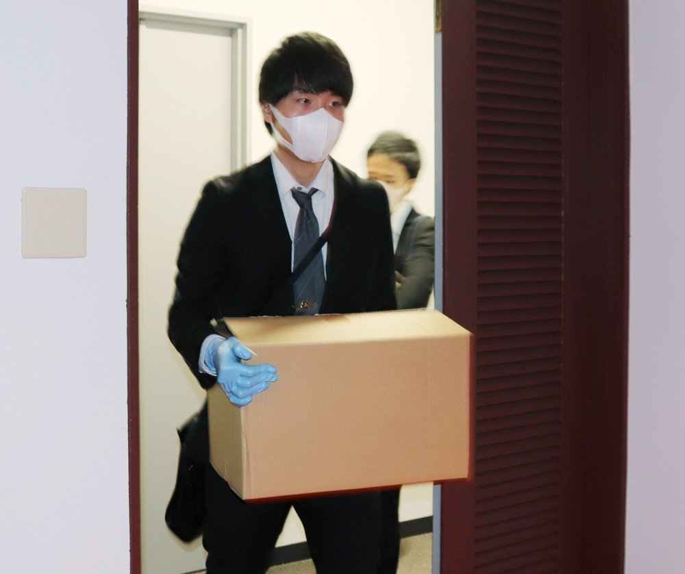 自民党の河井案里参院議員陣営の選挙違反事件をめぐり、元広島県議会議長の県議会控室の捜索を終え、段ボール箱を運び出す広島地検の係官ら