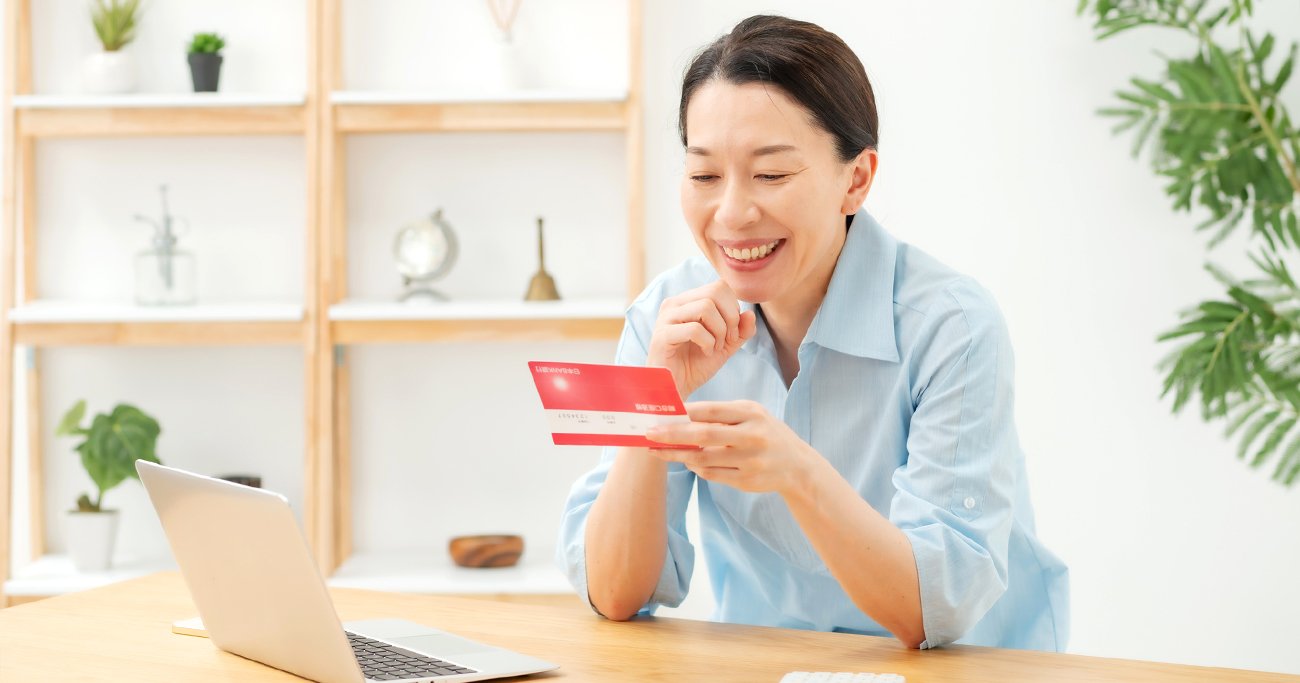 通帳を手に笑顔を見せる女性