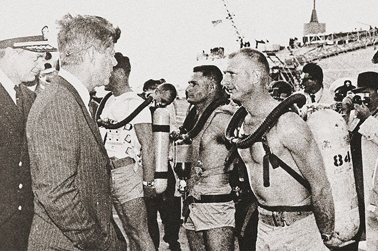 右はフィフティ ファゾムスを着用したアメリカ海軍特殊部隊のダイバー。左はその特殊部隊員たちと言葉を交わす、第35代アメリカ大統領ジョン・F・ケネディ