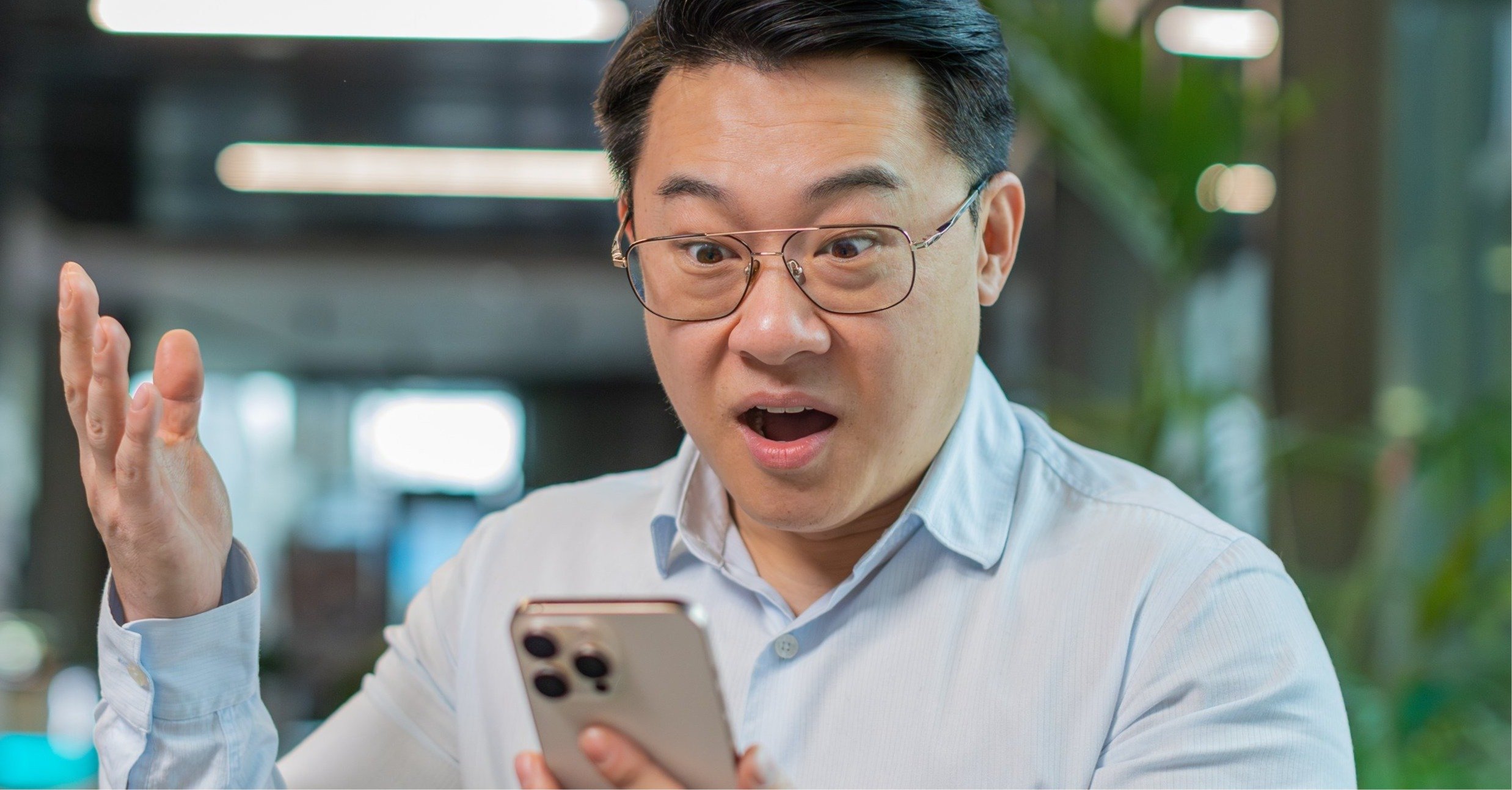 スマホを見て驚く男