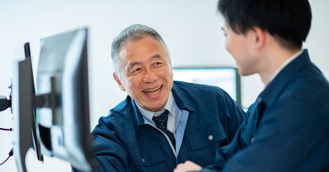 笑顔で話すベテラン社員と若手社員