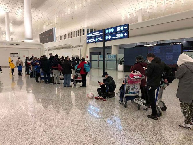 武漢の空港で7日、米政府が派遣した輸送機に乗るため列を作る米国人ら