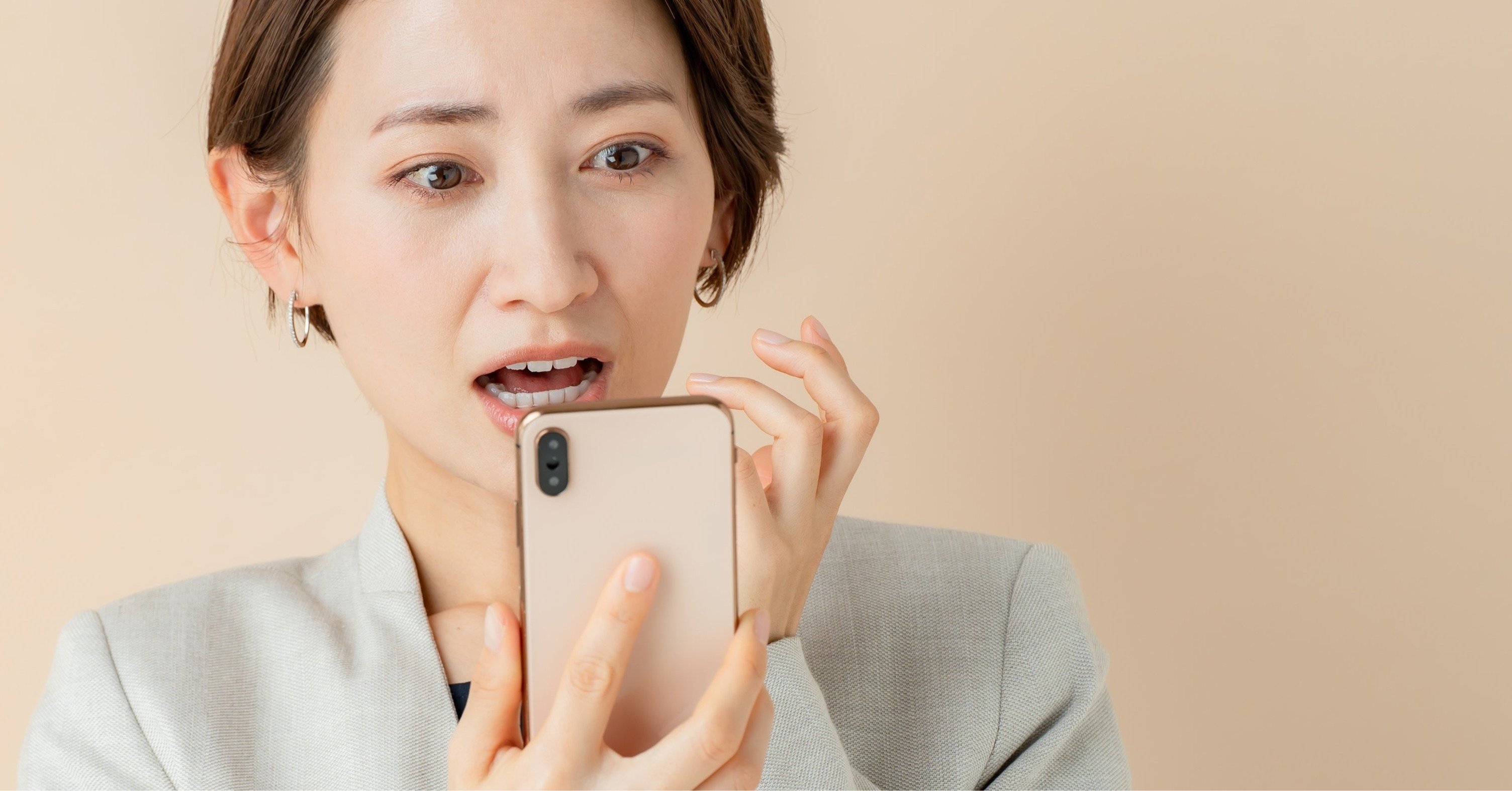 スマホを見てビックリする女性