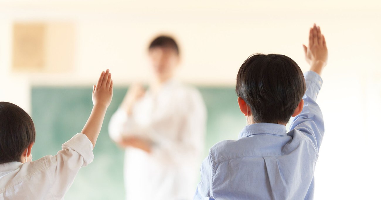 教室で手を挙げる子どもたち