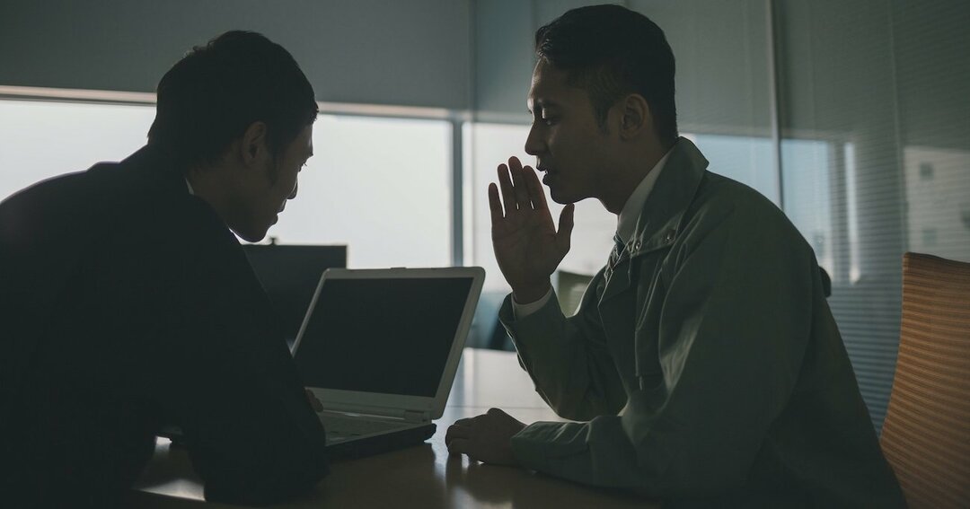 内緒話をする男性2人のイメージ写真