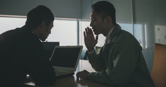 内緒話をする男性2人のイメージ写真