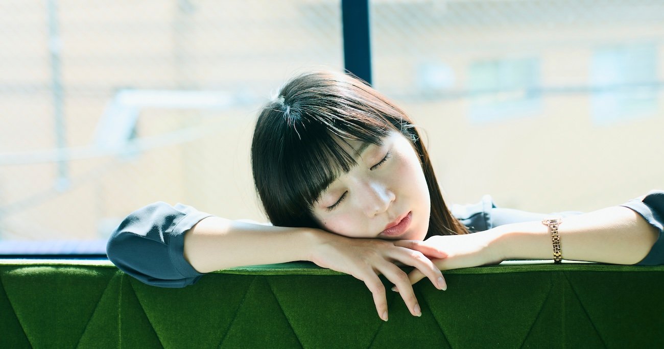 目を瞑って椅子にもたれかかる女性