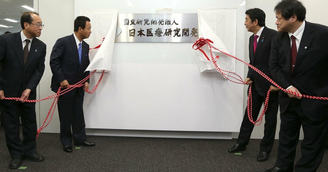 和泉洋人氏（左）は安倍晋三首相らとともに、「日本医療研究開発機構（ＡＭＥＤ）」の発足式に出席し、看板の除幕も行っている（2015年4月3日撮影）