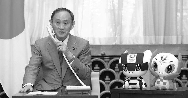 東京五輪柔道男子60キログラム級で金メダルを獲得した高藤直寿と電話で話す首相の菅義偉。人気取りのための行為と映り、内閣支持率の回復にはつながっていないようだ［代表撮影］