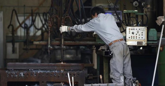 工場内で機械を操作する作業員