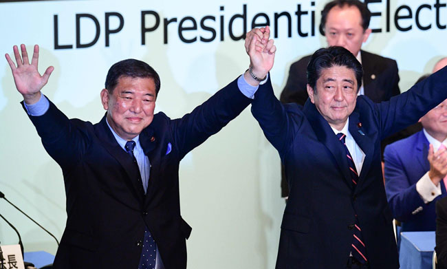自民党総裁選を戦った石破元幹事長(左)と安倍首相