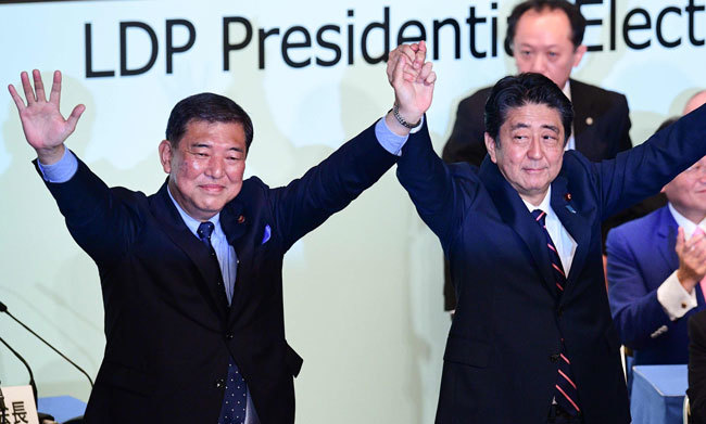 自民党総裁選を戦った石破元幹事長（左）と安倍首相