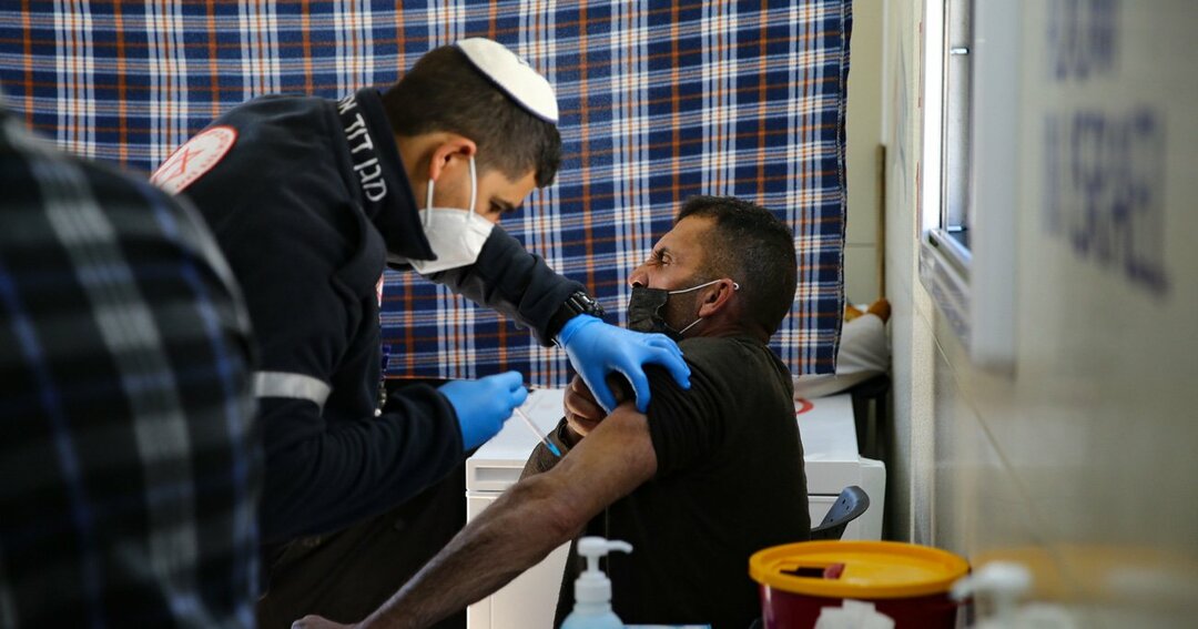 アルアクサに到着した移動式予防接種クリニックで、イスラム教徒に新型コロナワクチンを接種するユダヤ人の医療従事者　