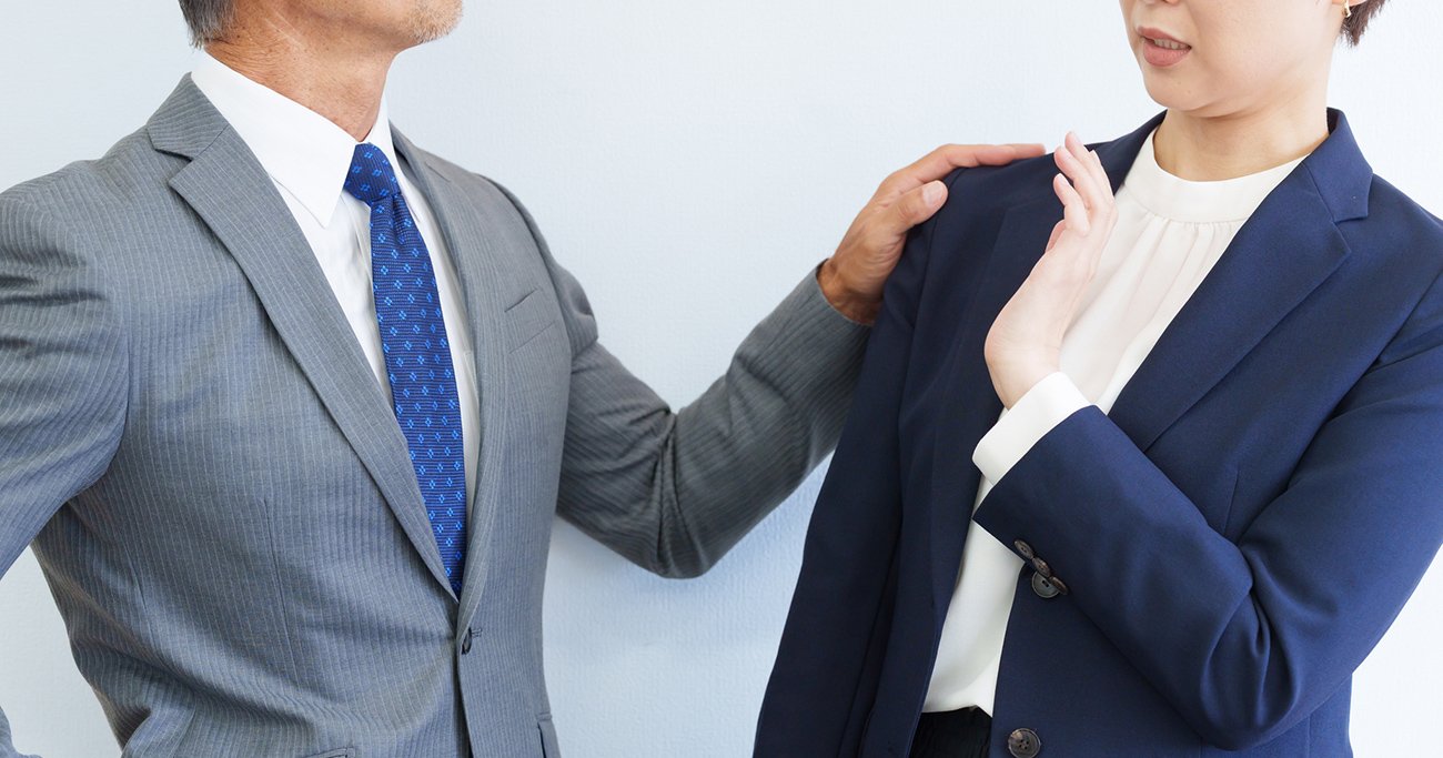 肩に手を置く男性上司を拒む女性社員