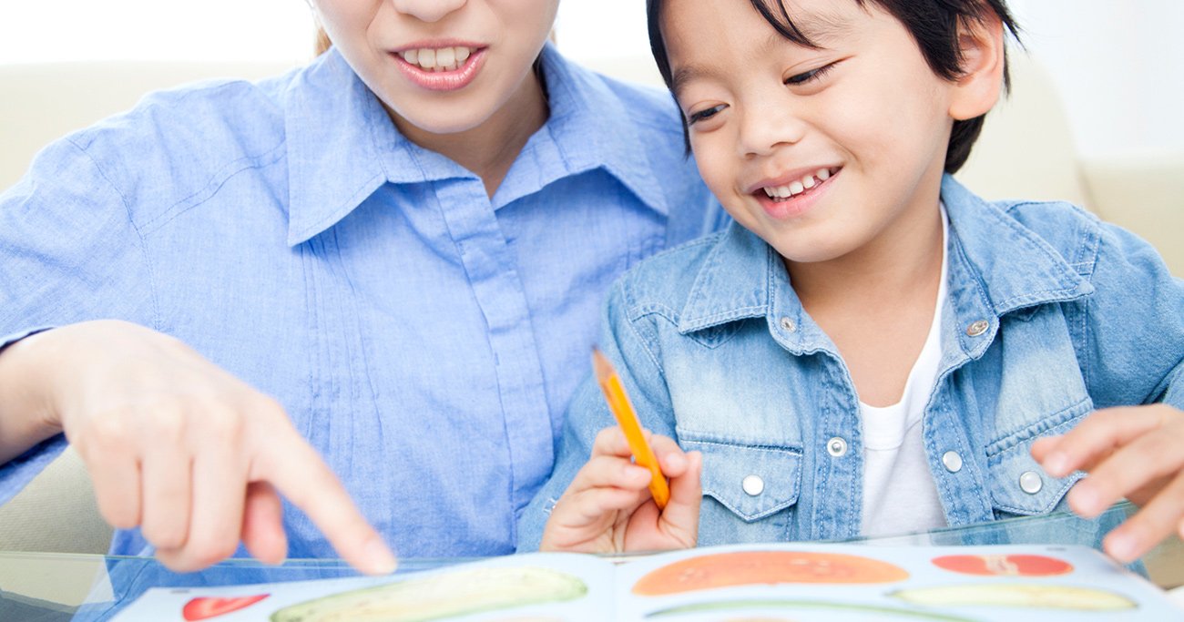 教材を見ながら一緒に学ぶ保護者と子ども