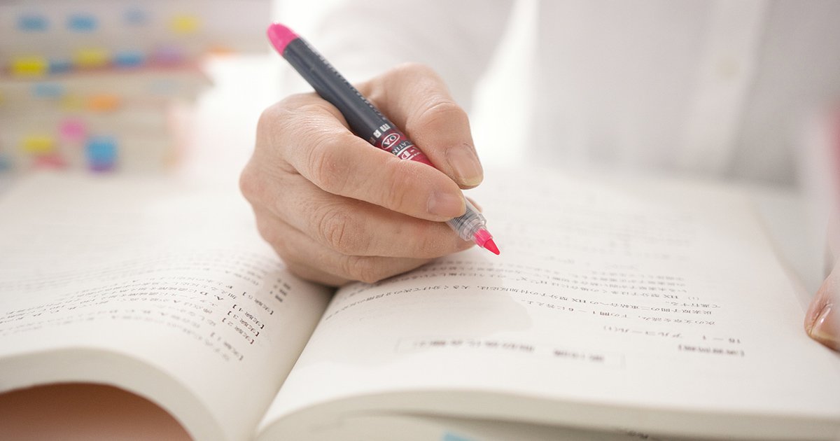 書籍を読みながらマーカーを引く様子