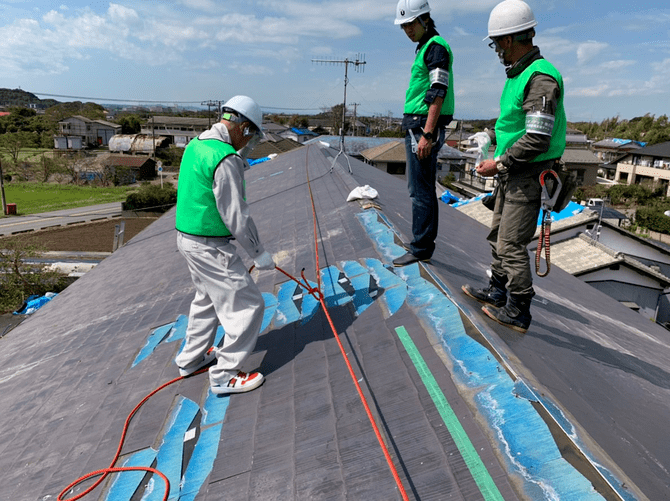 台風で被災した家の屋根にブルーシートを張る職人たち（提供：ユニオンテック）