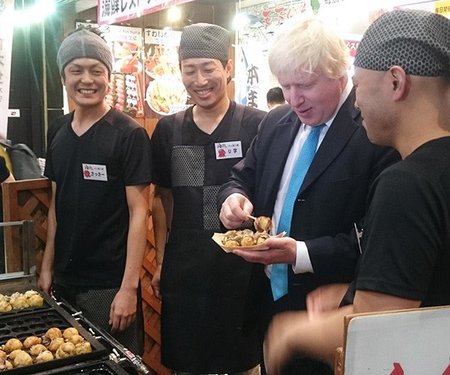 大阪・道頓堀でたこ焼きをほおばるジョンソン首相（2015年当時はロンドン市長）。
（出所）　英国大使館国際通商部公式ツイッター