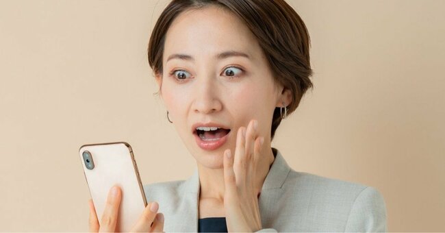 スマホを見て驚く女性