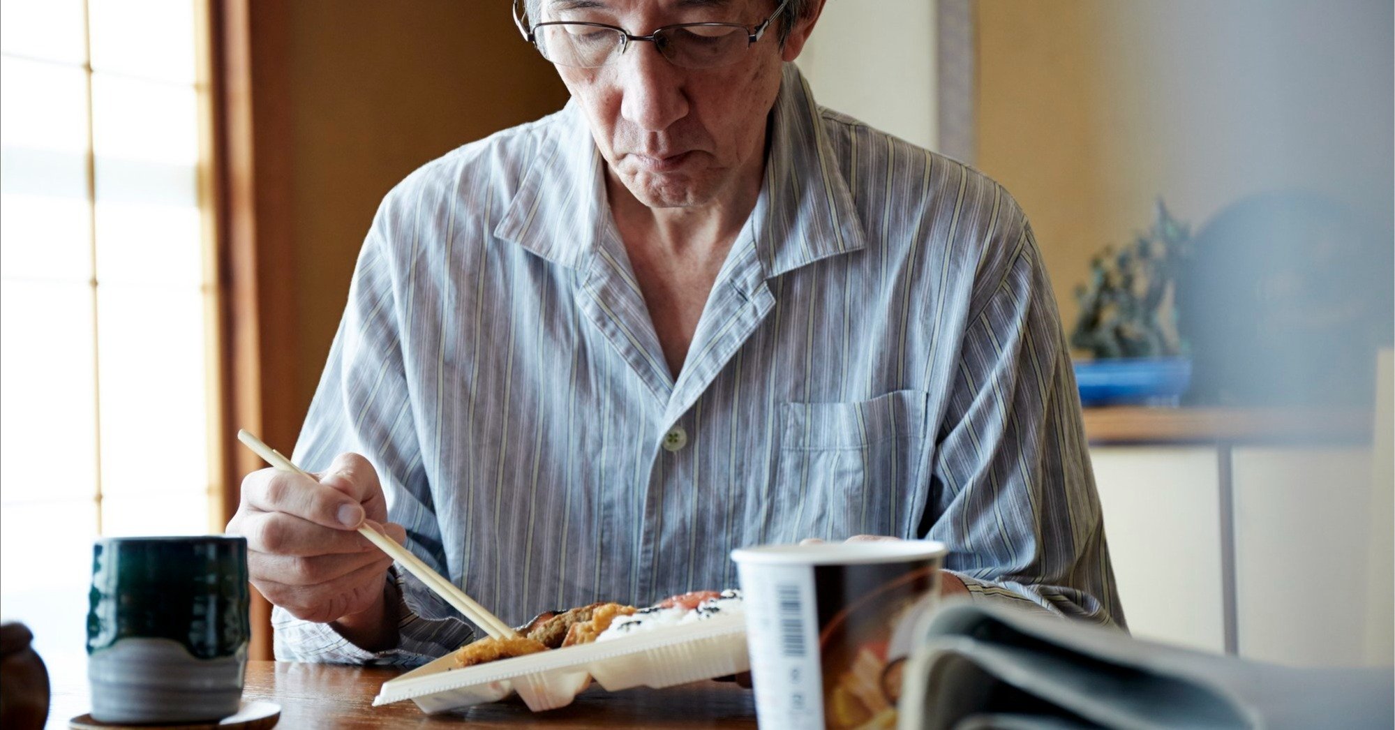 1人で食事をする高齢男性