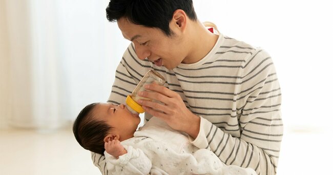 赤ちゃんにミルクを与える男性