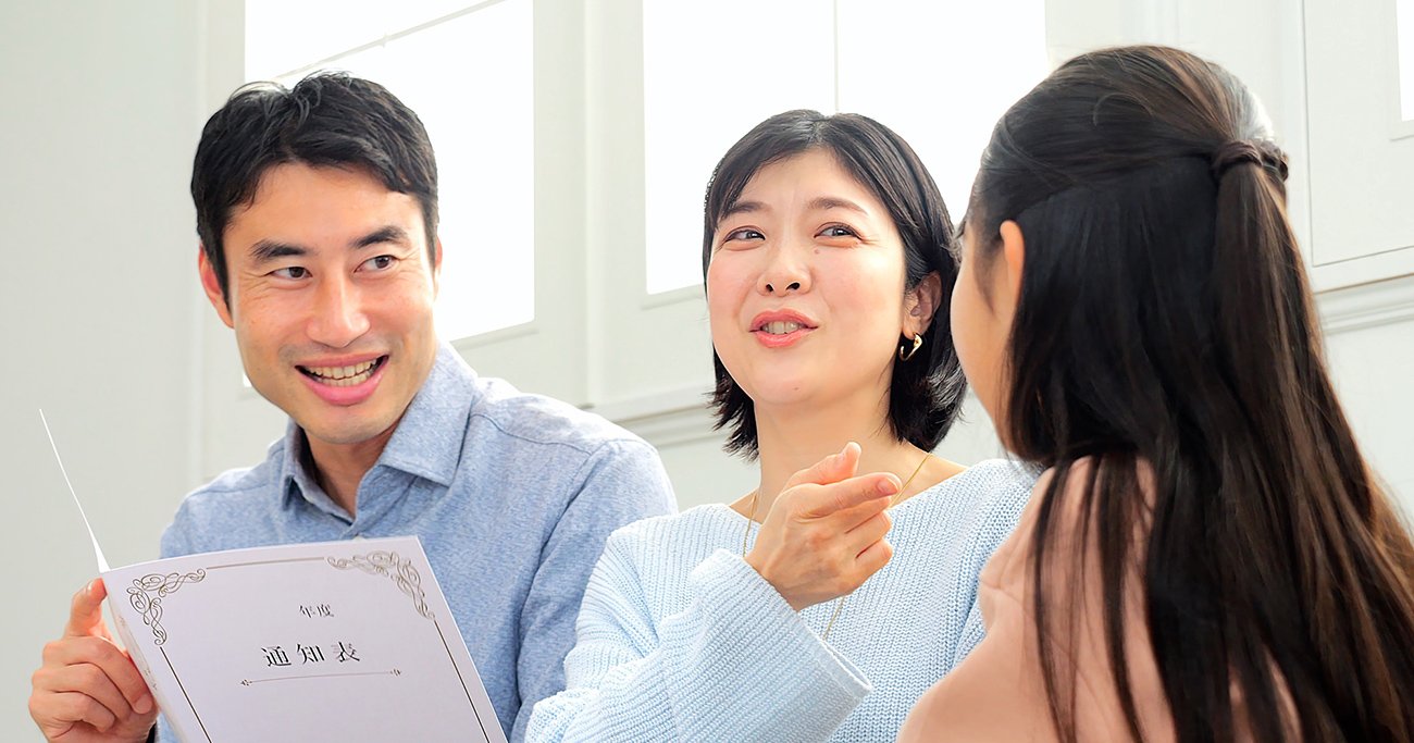 通知表を持ちながら話をする保護者と子ども