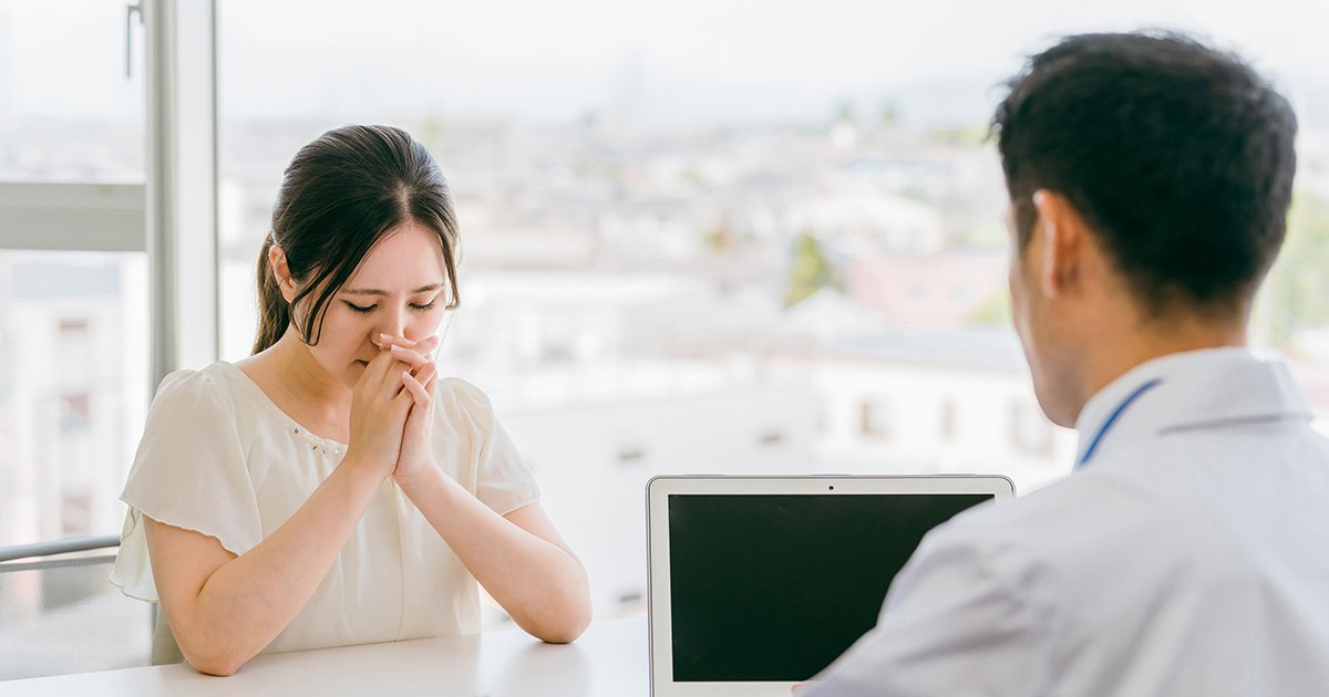 医師と向き合う悲しい顔の女性