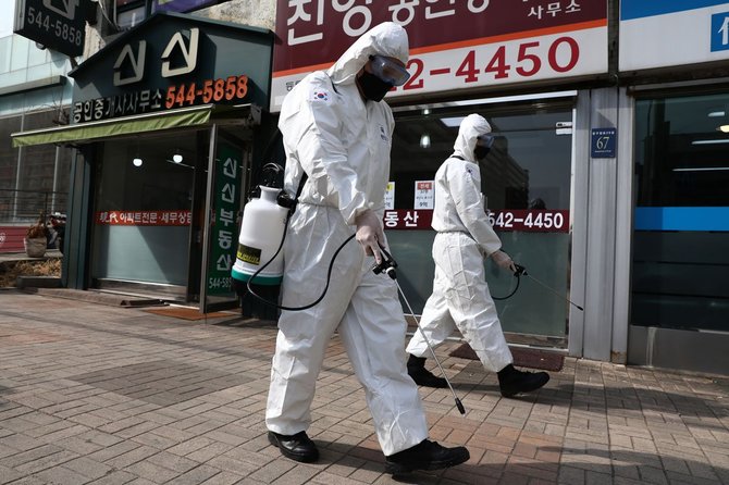韓国・ソウル市で消毒剤を撒く防護服姿の韓国軍兵士(3月9日撮影)