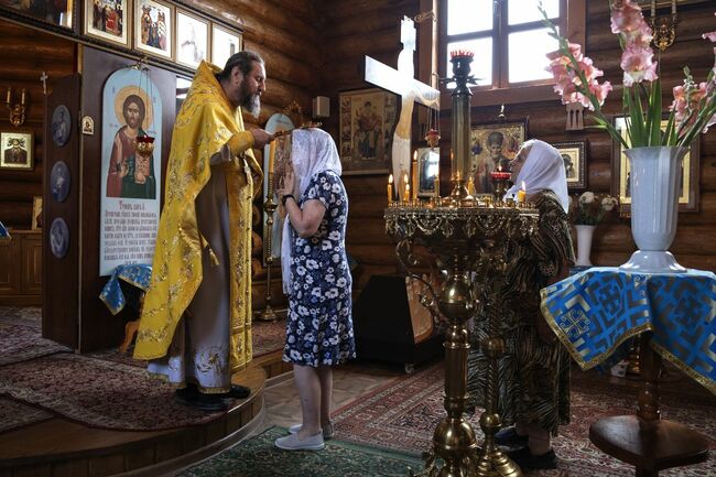 Father Iosif, in gold, at the Church of the Icon of the Mother of God near Moscow and Father Vasyl, in blue, at the Temple of the Holy Myrrh Bearing Women in Kharkiv, Ukraine.