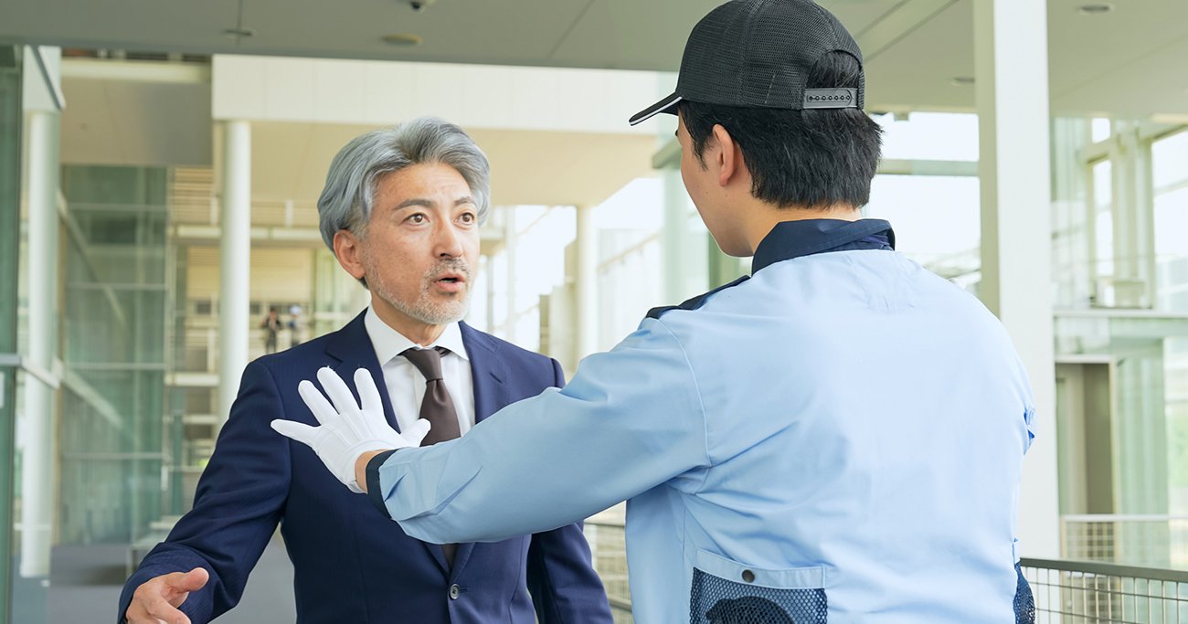 男性を制止する警備員