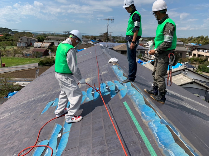台風で被災した家の屋根にブルーシートを張る職人たち(提供:ユニオンテック)