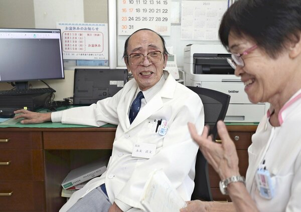 看護師と談笑する永末さん（福岡市西区の拾六町病院で）〈読売新聞提供〉　同書より転載