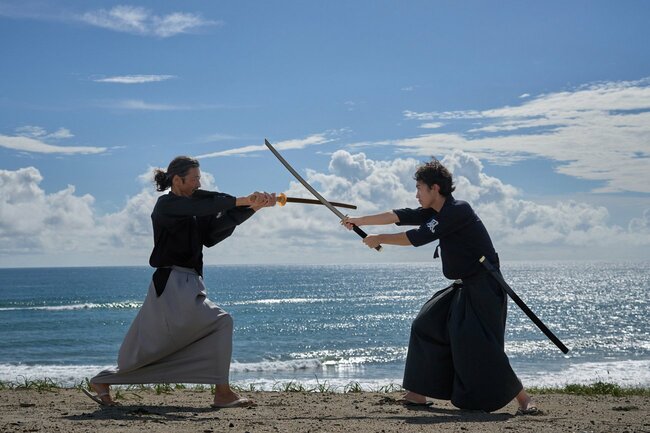 写真:海辺で対決する2人の侍