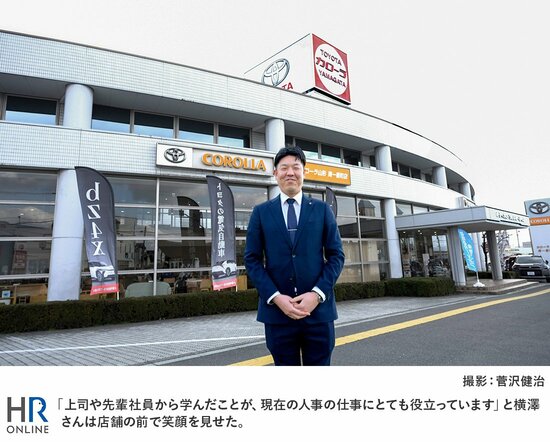 「上司や先輩社員から学んだことが、現在の人事の仕事にとても役立っています」と横澤さんは店舗の前で笑顔を見せた。