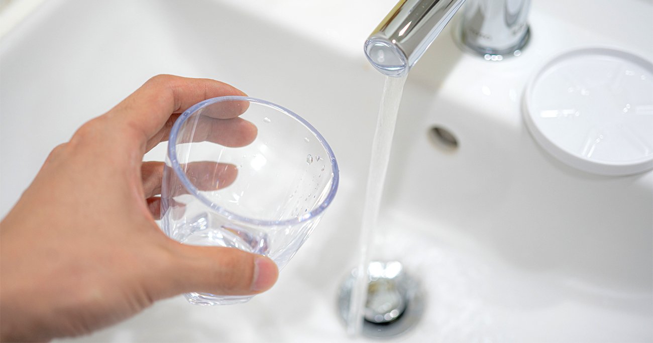 水が出ている蛇口とコップ