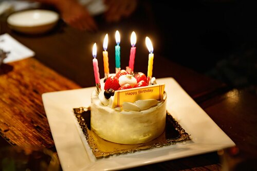 ロウソクが灯った誕生日ケーキ