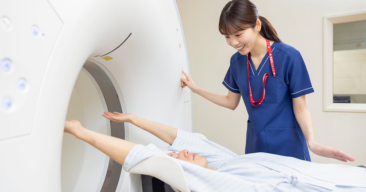 CTスキャンを受ける男性と放射線技師