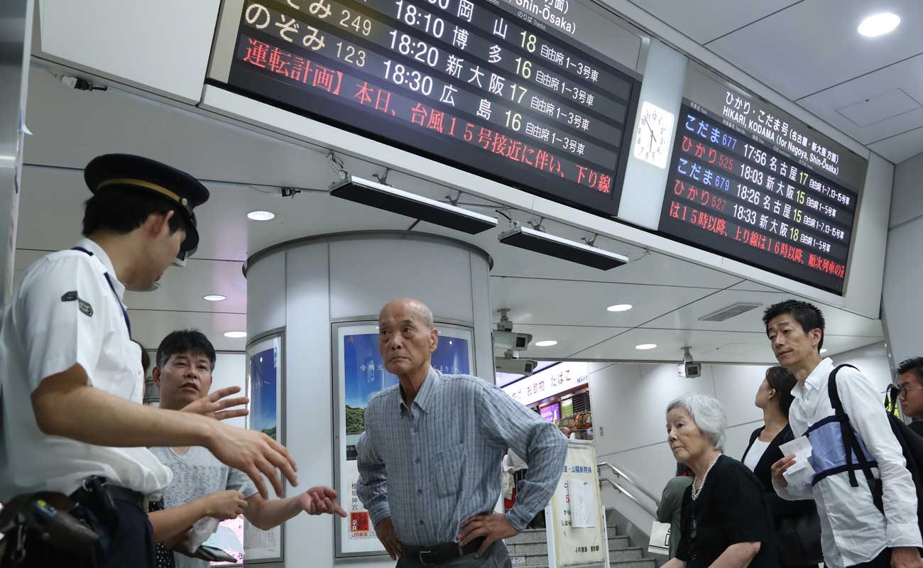 計画運休を知らせる電光掲示板と駅員