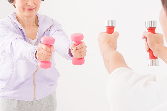 ダンベルを持ち運動する女性