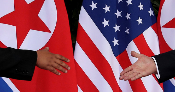 シンガポールで握手をする米国のトランプ大統領と、北朝鮮の金委員長