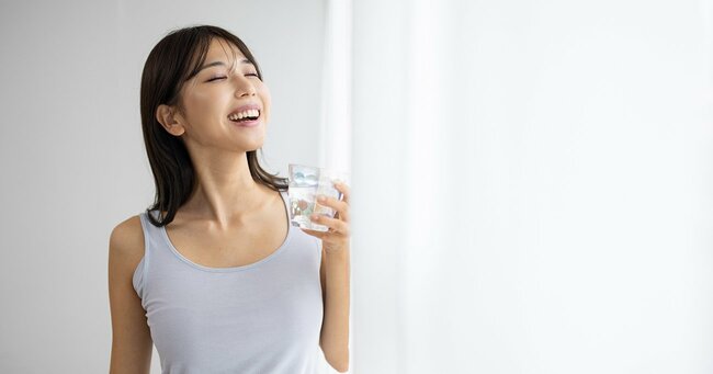コップの水を飲む女性
