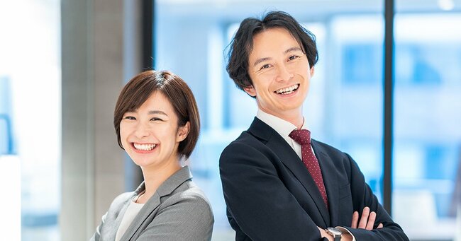 背中合わせで腕を組むビジネスパーソン
