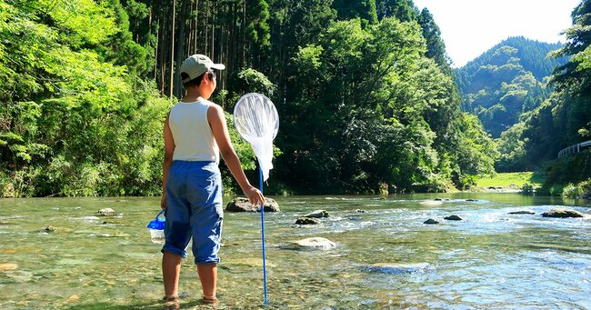 川の中で立つ少年