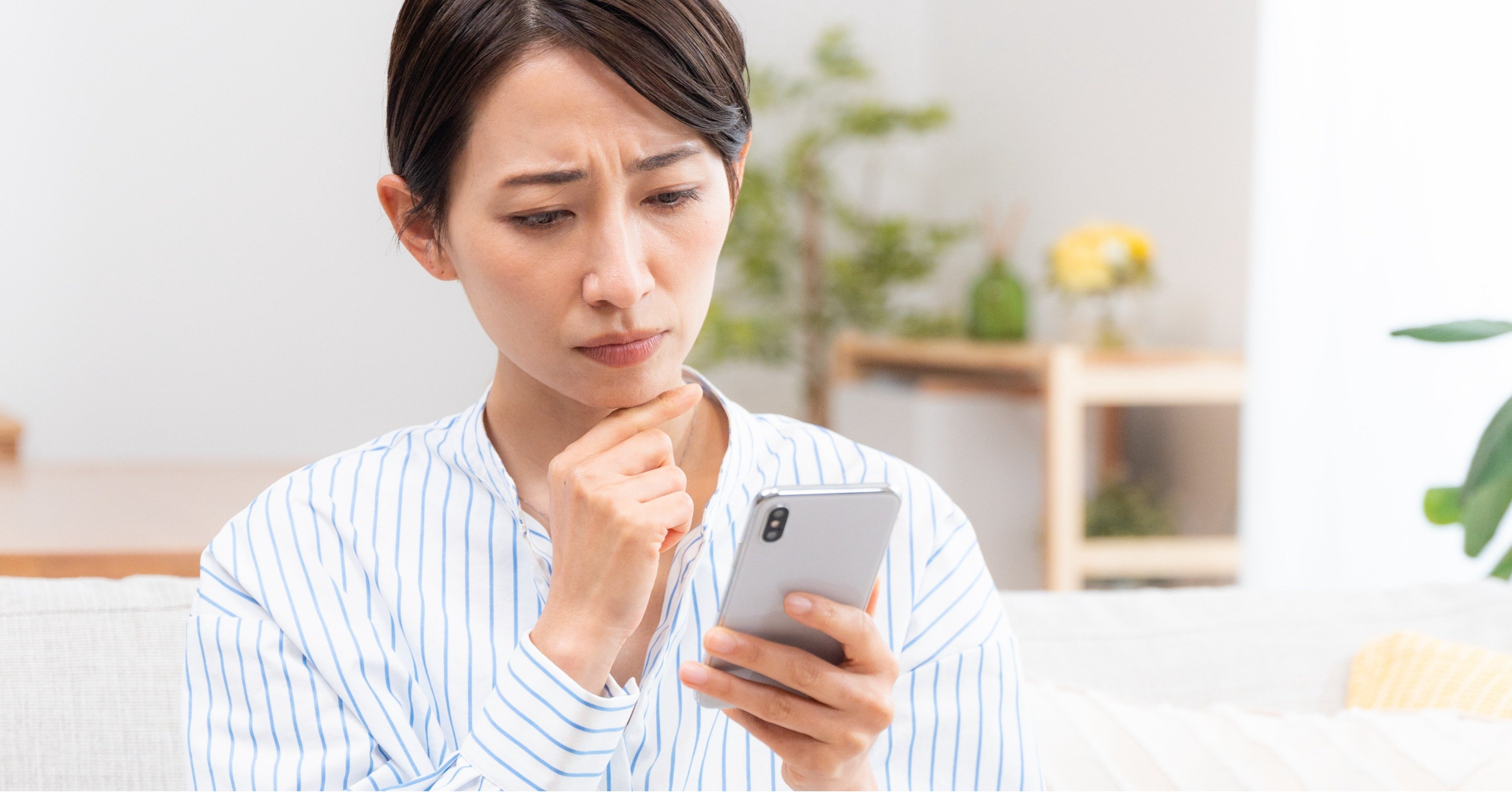 スマホを見て悲しげな表情になる女性