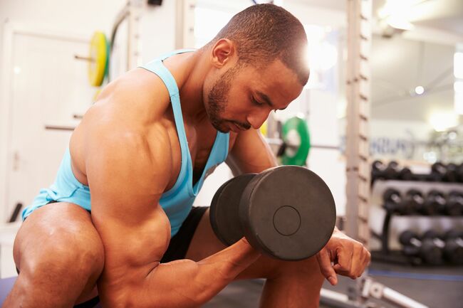 man exercising with dumbbells at a gym, horizontal shot